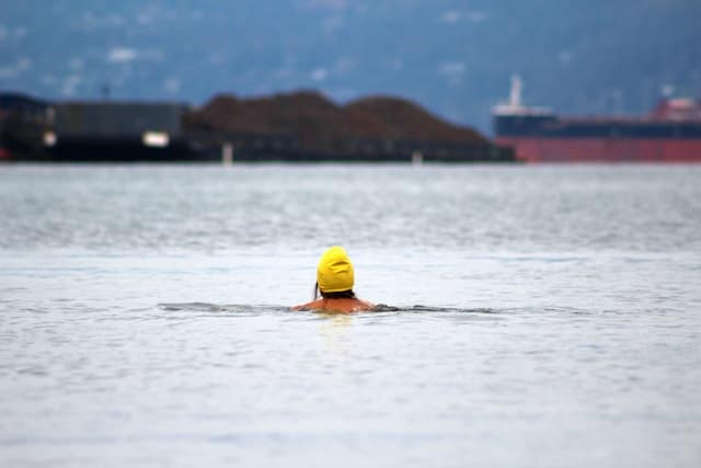 women swimming with swim cap on in cold water