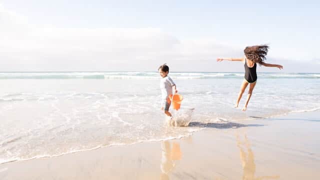 a boy and a girl playing in the sea