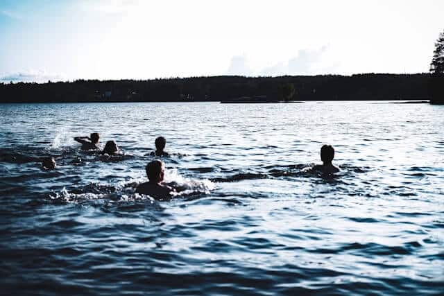 people wild swimming in lake