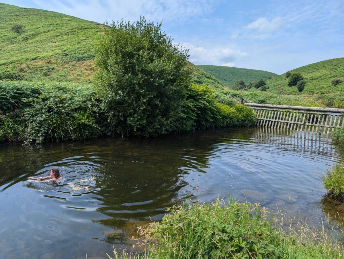 The Cow Castle wild swimming pool with a woman swimming in it