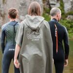 3 people wearing wild swimming robes and wesuits